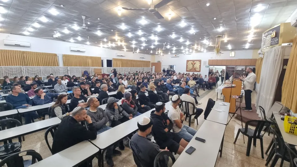 אולם בית המדרש מלא בקהל של נשים וגברים, צעירים ומבוגרים, בערב לימוד עם הרב ליאור